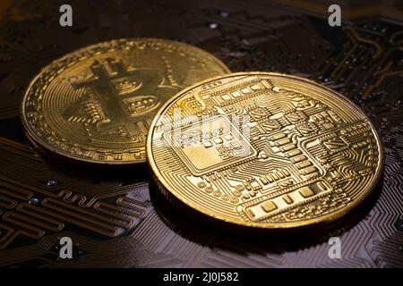 Two Bitcoin coins and printed circuit board PCB Stock Photo
