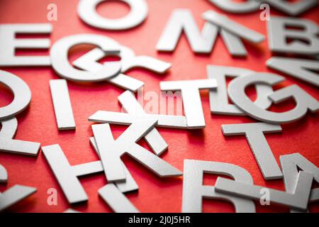 Mixed letters pile close up view photo. Red background Stock Photo