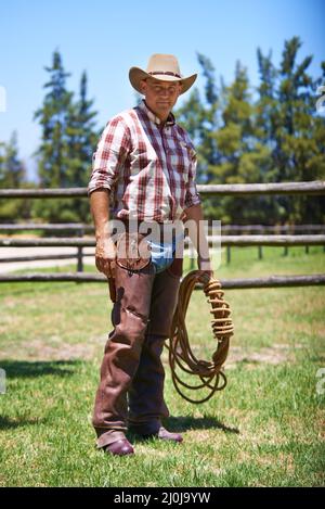 Time to rustle up some outlaws. A mature cowboy outdoors on his farm. Stock Photo