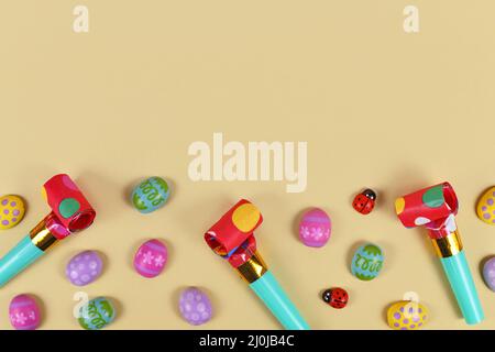 Easter party egg ornaments, blowouts and ladybugs on yellow background with copy space Stock Photo