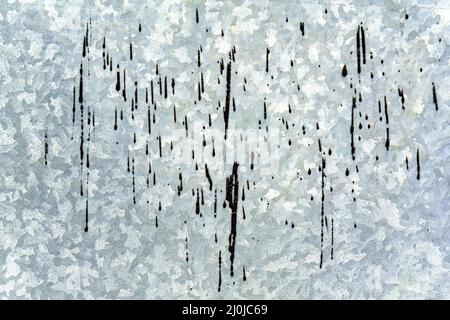 Silver background in the form of a sheet of galvanized textured steel with black drops of resin. Stock Photo