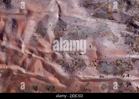 Dark pink abstract background with silver grey brown red and purple hues. A weathered, rust-eaten, crumpled textured sheet of metal. Stock Photo