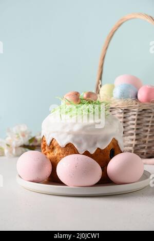 Homemade Easter cake, colorful eggs, easter basket for celebration religion custom. Vertical. Stock Photo