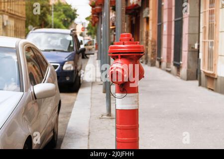 Red fire hydrant in city street. Fire hidrant for emergency fire access. Stock Photo