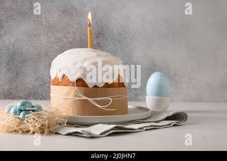 Homemade traditional Easter cake, decorative nest with blue eggs on gray background with copy space. Greeting card. Stock Photo