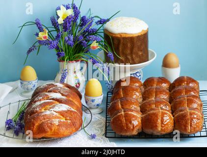 Traditional Easter pastries, cross buns, Easter cake and sweet challah and Easter eggs. Stock Photo