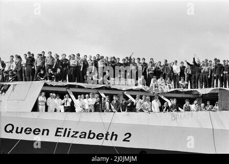 QE2 returns home to Southampton. Union Jacks are festooned on cars, draped on shoulders, waved on sticks. Southampton gives a 'Three Cheers' welcome to the QE2 luxury liner turned trooper returning from war. Aboard is her precious cargo, the 700 survivors from the HMS Coventry, Ardent and Antelope, sunk in the battle for the Falklands. 11th June 1982. Stock Photo
