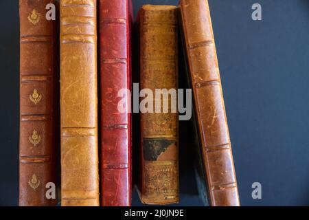 Row of old books on dark background Stock Photo