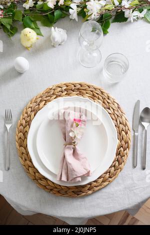 Festive Easter table setting with spring decorations, natural organic egg, yellow chick on linen tablecloth. Elegance dinner at home interior. Christi Stock Photo