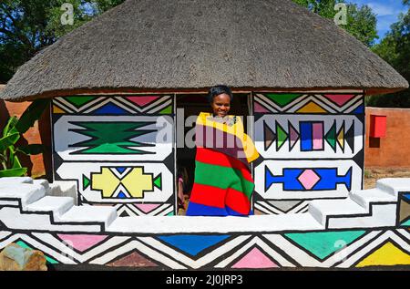 Ndebele woman and hut at Motseng Cultural Village, Sun City Resort, Pilanesberg, North West Province, Republic of South Africa Stock Photo