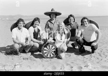 British darts player Eric Bristow poses on the beach with Maureen Flowers and fellow British drafts players at Torremolinos Del Mar on the Costa Del Sol in Spain ahead of the Mediterranean Open Darts Championship. 31st January 1982. Stock Photo