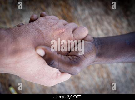 Two hands white and black making team Stock Photo