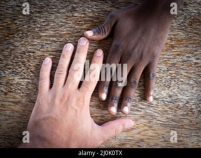Two hands white and black making team Stock Photo