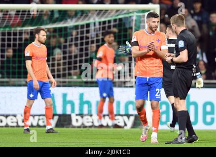 Bremen, Germany. 19th Mar, 2022. Soccer: 2nd Bundesliga, Werder Bremen - Darmstadt 98, Matchday 27, wohninvest Weserstadion. Referee Robert Schröder talks to Darmstadt's Klaus Gjasula (l) after showing him the red card for foul play after watching the video. Credit: Carmen Jaspersen/dpa - IMPORTANT NOTE: In accordance with the requirements of the DFL Deutsche Fußball Liga and the DFB Deutscher Fußball-Bund, it is prohibited to use or have used photographs taken in the stadium and/or of the match in the form of sequence pictures and/or video-like photo series./dpa/Alamy Live News Stock Photo