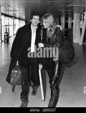 Keith Richards guitarist with the Rolling Stones leaving Heathrow with his girlfriend Patti Hansen on Concorde for New York on 20th December 1982 Stock Photo