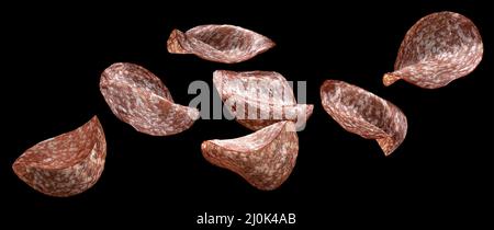 Falling salami slices isolated on black background Stock Photo
