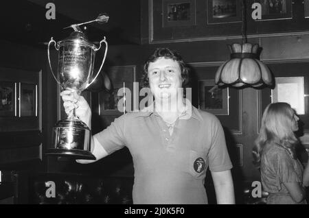 British darts player Eric Bristow celebrates his victory over John Lowe in the Final of the 1981 Embassy World Darts Championship at Jollees Cabaret Club in Stoke on Trent.  Here he is pictured holding the trophy after his 5-3 sets victory. 17th January 1981. Stock Photo