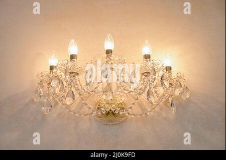 Vintage sconce glows on the wall Stock Photo