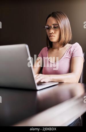 Its easier for her to concentrate on work at home. Cropped shot of an attractive young businesswoman working from home. Stock Photo