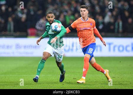 Bremen, Germany. 19th Mar, 2022. Soccer: 2nd Bundesliga, Werder Bremen - Darmstadt 98, Matchday 27, wohninvest Weserstadion. Werder's Manuel Mbom (l) fights Darmstadt's Mathias Honsak for the ball. Credit: Carmen Jaspersen/dpa - IMPORTANT NOTE: In accordance with the requirements of the DFL Deutsche Fußball Liga and the DFB Deutscher Fußball-Bund, it is prohibited to use or have used photographs taken in the stadium and/or of the match in the form of sequence pictures and/or video-like photo series./dpa/Alamy Live News Stock Photo