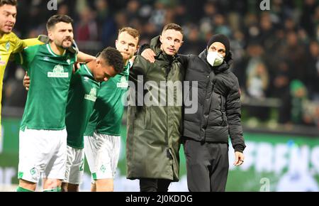 Bremen, Germany. 19th Mar, 2022. Soccer: 2nd Bundesliga, Werder Bremen - Darmstadt 98, Matchday 27, wohninvest Weserstadion. Werder celebrates with the injured Marco Friedl (2nd from right) and Ömer Toprak (right). Credit: Carmen Jaspersen/dpa - IMPORTANT NOTE: In accordance with the requirements of the DFL Deutsche Fußball Liga and the DFB Deutscher Fußball-Bund, it is prohibited to use or have used photographs taken in the stadium and/or of the match in the form of sequence pictures and/or video-like photo series./dpa/Alamy Live News Stock Photo