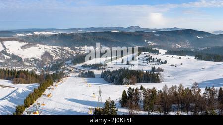 Panoramic winter view of ski slope in Beskid Sadecki mountains at sunny day Stock Photo