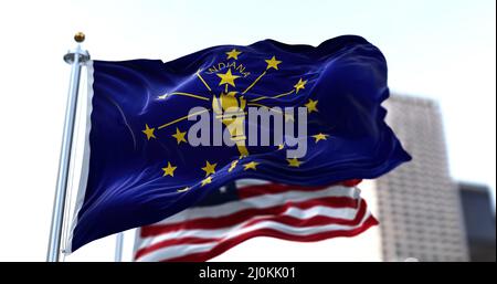 The flag of the US state of Indiana waving in the wind with the American flag blurred in the background Stock Photo