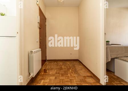 Distributor corridor of a residential house with entrance to a furnished living room and oak parquet floors Stock Photo