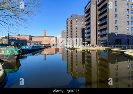 Murrays' Mills and the Cotton Field Wharf apartment blocks reflected in the Cotton Field Park marina, New Islington, Ancoats, Manchester, England, UK Stock Photo