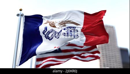 The flag of the US state of Iowa waving in the wind with the American flag blurred in the background Stock Photo