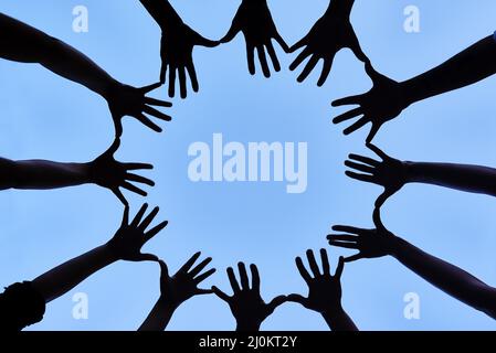 Collaborating as one. Shot of a group of hands spread out together in a circle. Stock Photo