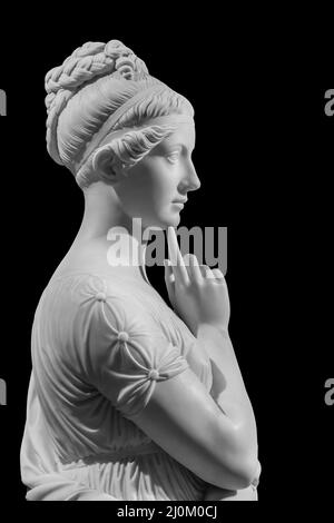 Gypsum copy of ancient statue of thinking young lady isolated on black background. Side view of plaster sculpture woman face Stock Photo