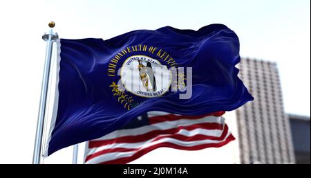 The flag of the US state of Kentucky waving in the wind with the American flag blurred in the background Stock Photo