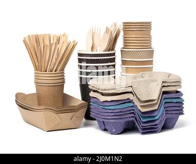 Stack of brown disposable paper cups, wooden forks and knives, plate on a white background. Utensils for takeaway drinks Stock Photo