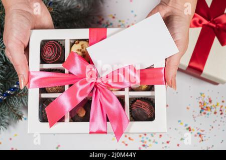 Handmade chocolate truffle candies in a white box on a christmas background. Directly above top view. Stock Photo