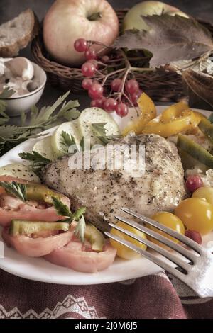 Baked chicken leg on a plate with vegetables Stock Photo