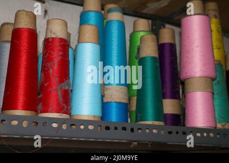 Set of colored threads for sewing on coils. Pile of big colorful spools of thread. Colored thread spools of thread large class, textiles, background Stock Photo