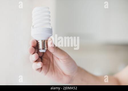Human hand holding compact fluorescent light bulb Stock Photo