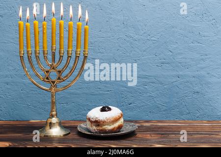 Jewish menorah with tasty donut Stock Photo
