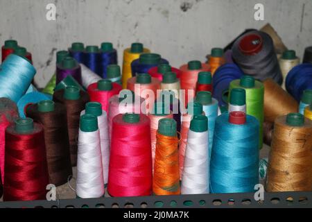 Set of colored threads for sewing on coils. Pile of big colorful spools of thread. Colored thread spools of thread large class, textiles, background Stock Photo