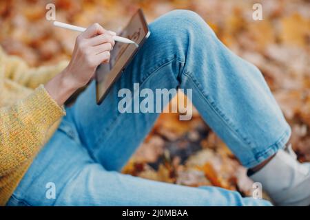 MOSCOW, RUSSIA - OCTOBER 19, 2021: Young woman model in autumn park with yellow foliage maple leaves. Fall season fashion. Stock Photo