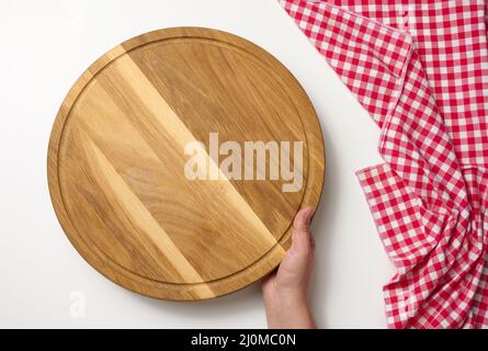 Woman holding empty round wooden pizza board in hand, body on a white background, top view Stock Photo