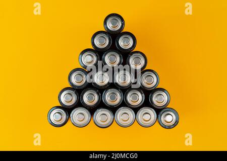 Used batteries are arranged in a triangle shape. Recycling and disposal of toxic waste. Stock Photo