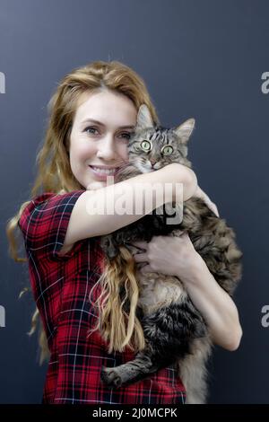 Girl hugging a striped surprised cat. Love for cats. Cats are happiness Stock Photo