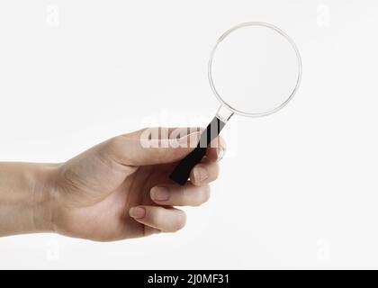 Hand holding magnifying glass Stock Photo