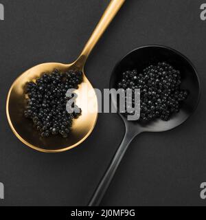 Golden and black spoon with caviar Stock Photo - Alamy