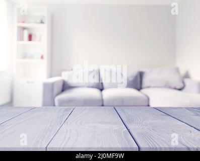 Gray wooden table front blur white sofa living room Stock Photo