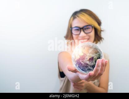 Earth in hand. World, small globe hold and showing by happy Asian woman's hand on white background with copy space. Earth day. Global connection, comm Stock Photo