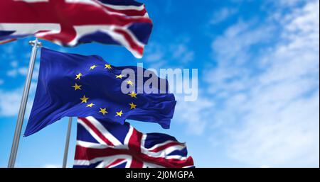 The Flag of the European Union Waving Between Two Flags of United Kingdom with clear sky on the background Stock Photo