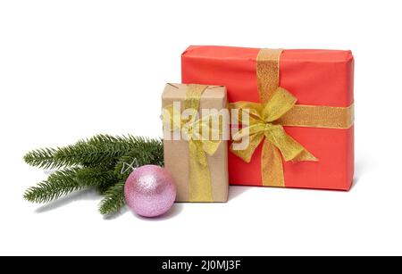 A stack of packing boxes in gift paper and ribbon, a branch of green needles on a white background. Merry christmas and happy ne Stock Photo